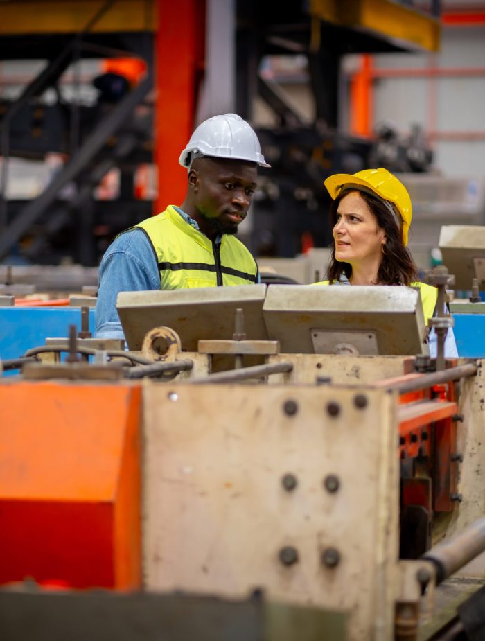 Team of young male and female engineers in a metal sheet factory Responsible work is being inspected at the actual work site. Work professionally and happily